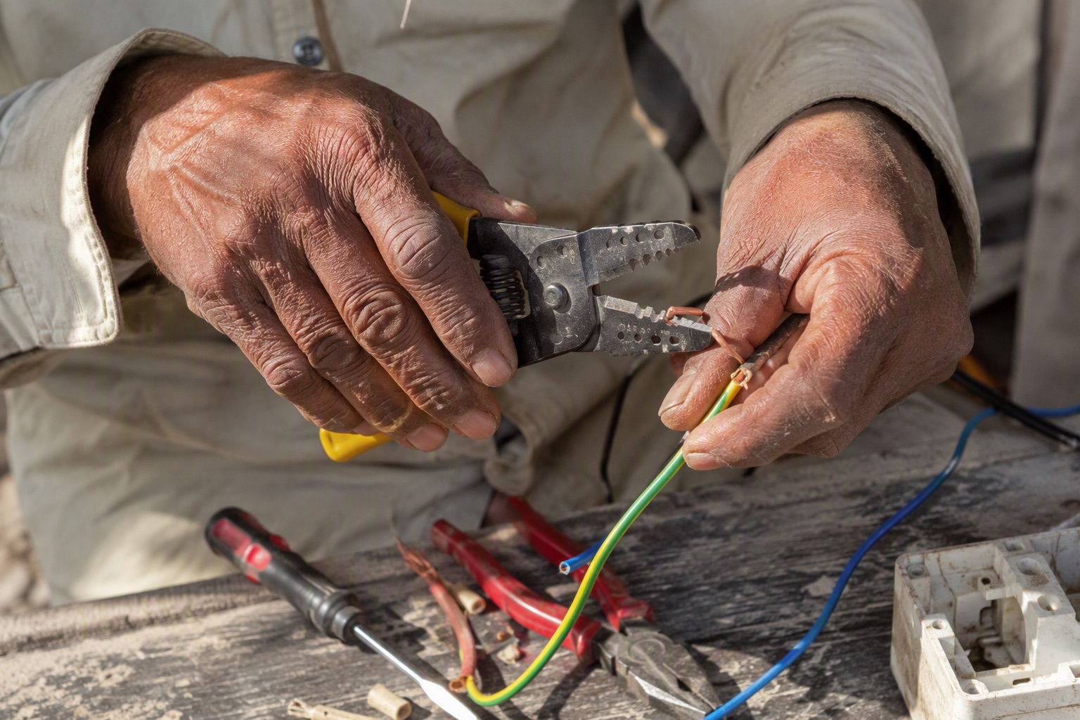 Close-up of an electrician stripping the insulation from a copper cable