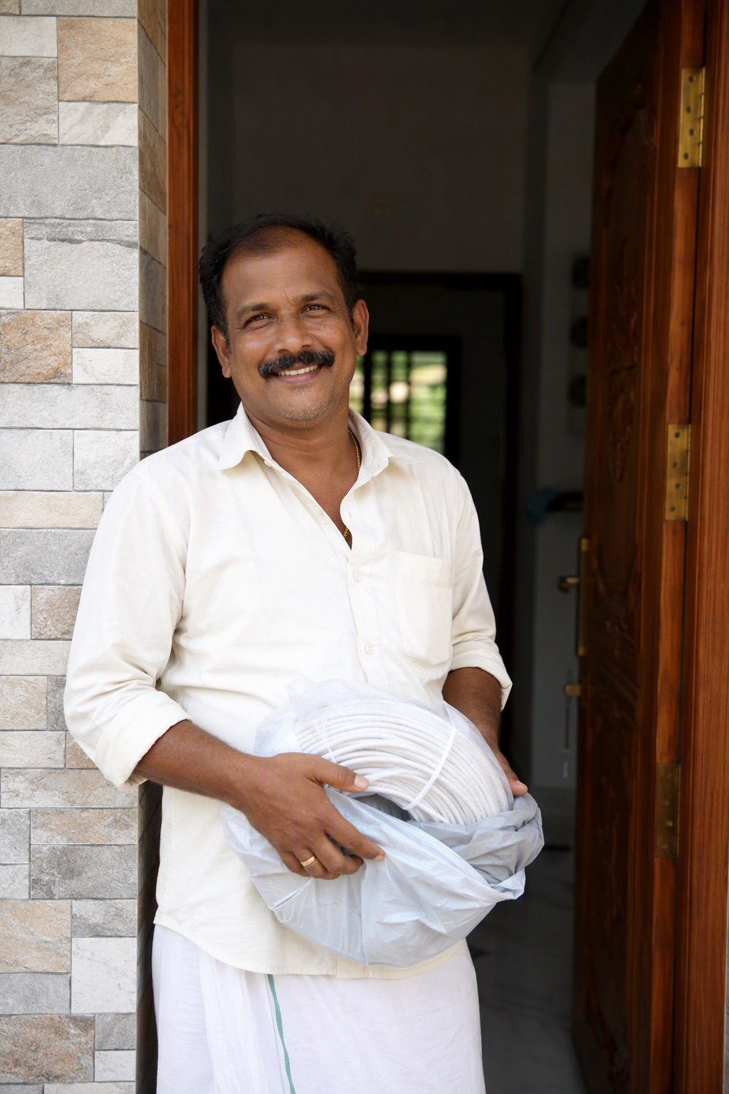 Homeowner in Bangalore holding a coil of house wiring cable for his new house